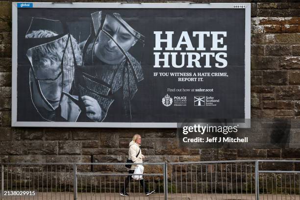 Member of the public walks past a hate crime billboard on April 04, 2024 in Glasgow, Scotland. The Hate Crime and Public Order Act, introduced on...