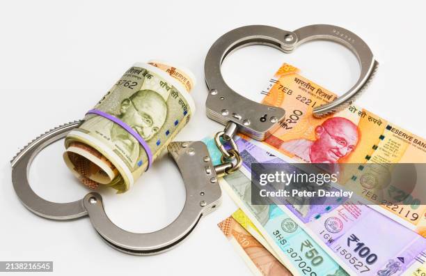 indian currency notes and handcuffs - money-talks-englische-redewendung stock-fotos und bilder
