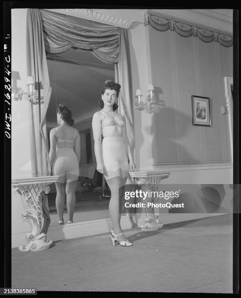 View of an unidentified model in a bra, girdle, and stockings during a fashion show at the Saks Fifth Avenue store, Detroit, Michigan, circa 1942.