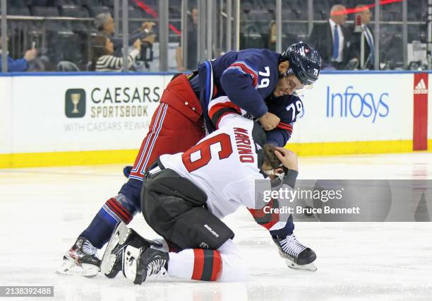 Andre Miller of the New York Rangers fights with John Marino of the New Jersey Devils during the first period at Madison Square Garden on April 03,...