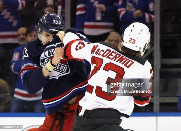 Kurtis MacDermid of the New Jersey Devils fights with Matt Rempe of the New York Rangers during the first period at Madison Square Garden on April...
