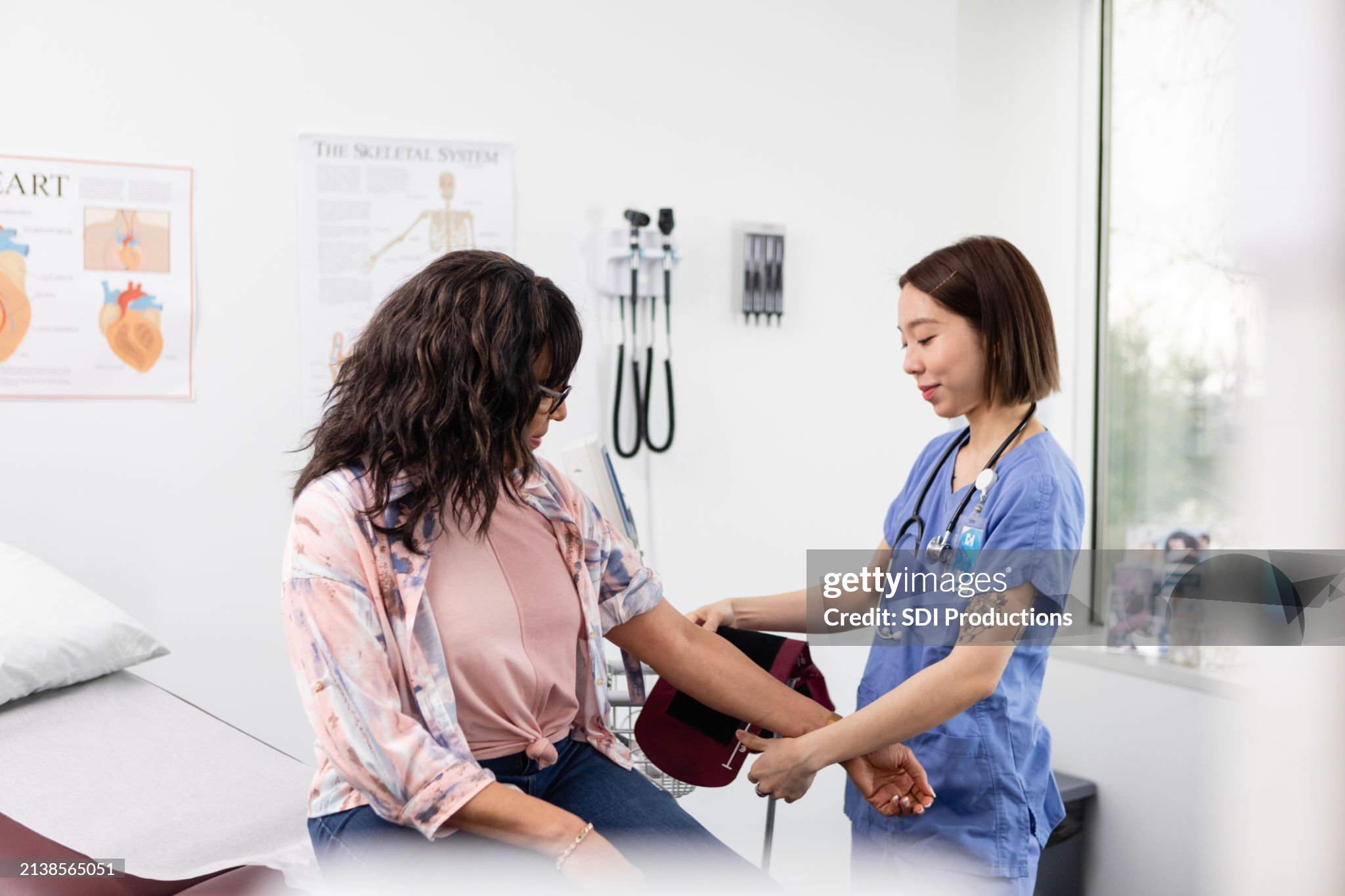 Jovem adulto técnica se prepara para medir a pressão arterial da mulher