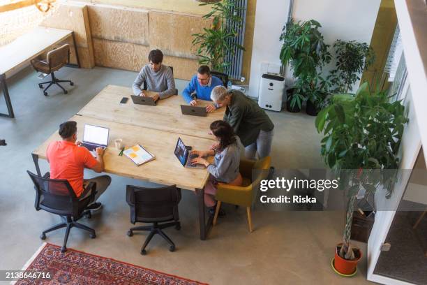 blick aus der vogelperspektive auf kollegen, die im büro arbeiten. offener raum - open space office stock-fotos und bilder