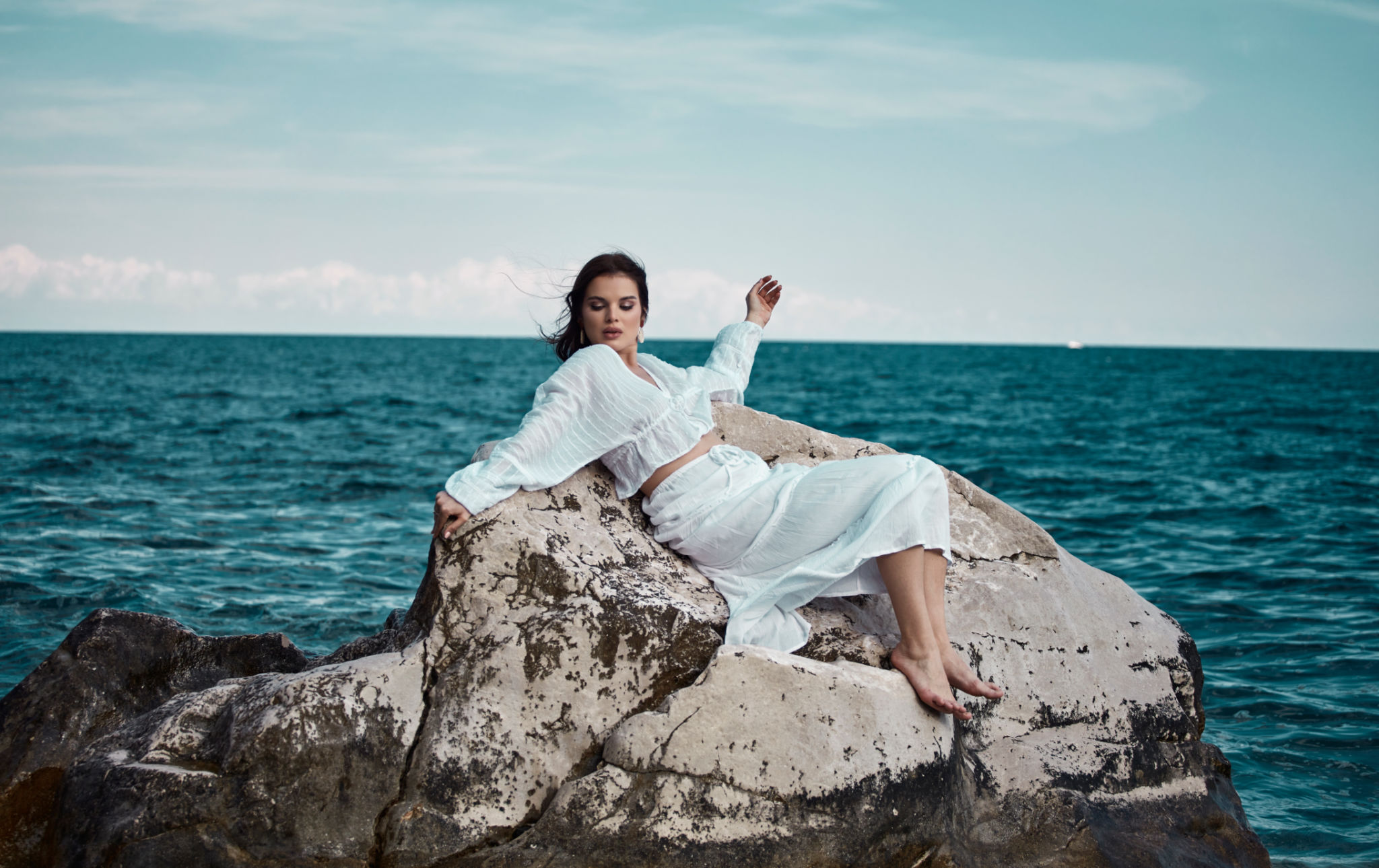 Young woman lying on a rock in the middle of the sea, having a pleasant time. Young woman lying on a rock in the middle of the sea, having a pleasant time.