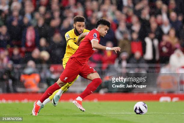 Luis Diaz of Liverpool runs with the ball whilst under pressure from Jayden Bogle of Sheffield United during the Premier League match between...