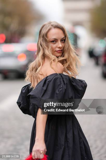 Anouchka Gauthier wears a black long gathered off-shoulders dress with oversized puff sleeves, outside Nina Ricci, during the Womenswear Fall/Winter...