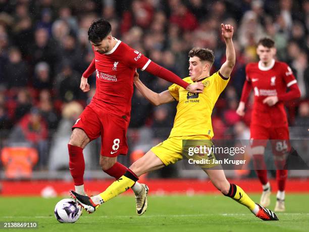 Dominik Szoboszlai of Liverpool is challenged by Oliver Arblaster of Sheffield United during the Premier League match between Liverpool FC and...