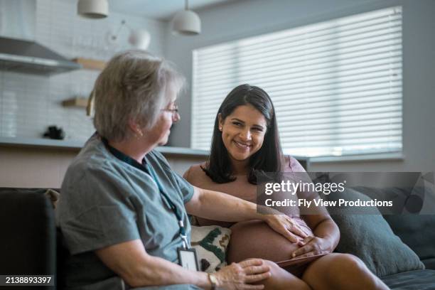 mujer embarazada multirracial que se somete a un chequeo con su médico - comadrona fotografías e imágenes de stock