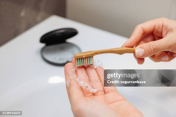 woman's hand holding invisible aligners. - aparelho dentário imagens e fotografias de stock