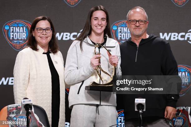 Executive Director Danielle Donehew and head coach Mike Neighbors of the Arkansas Razorbacks present the WBCA Wade Trophy to Caitlin Clark of the...