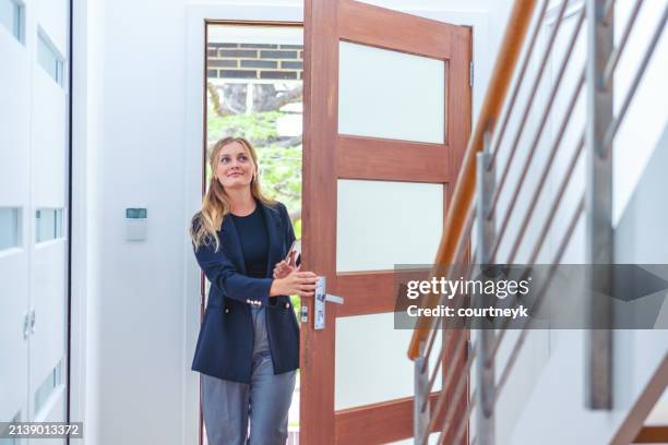 felice agente immobiliare o assicurativo che entra in una casa da solo. - entrare foto e immagini stock