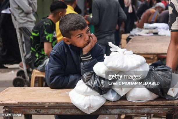 Palestinian child sells food items in a market, ahead of Eid al-Fitr celebrations which conclude the Muslim holy fasting month of Ramadan, in Rafah...