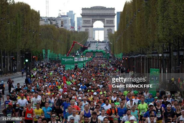 Runners take part in the Paris Marathon shortly after the start of the race in front of the Arc de Triomphe on the Champs-Elysees avenue, in Paris on...