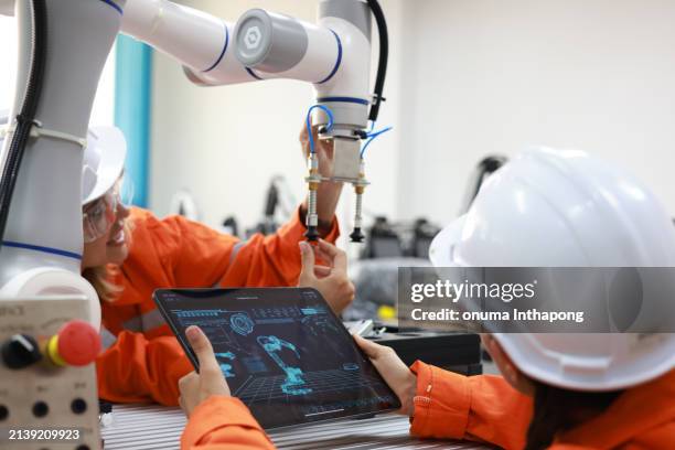 two talented female mechatronics engineers are collaborating seamlessly, leveraging advanced robotic arms to achieve remarkable results. - automatic stock pictures, royalty-free photos & images