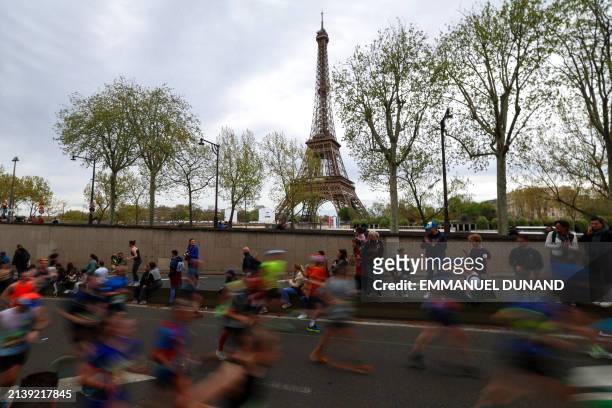 Participants run near the Eiffel Tower during the Paris Marathon, in Paris on April 7, 2024.