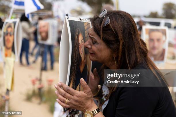 Orly Efraim reacts to a photo of her niece Eden Liza Auhaion, displayed near the marker of her niece who was killed on the October 7 Hamas deadly...