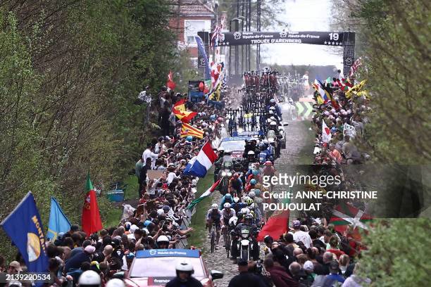 The pack of riders cycles over "La Trouee d'Arenberg" cobblestone sector 19 during the 121st edition of the Paris-Roubaix one-day classic cycling...