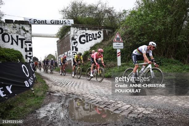 Alpecin - Deceuninck team's Dutch rider Mathieu Van Der Poel leads the pack of riders past the Pont Gibus at cobblestone sector 18 during the 121st...