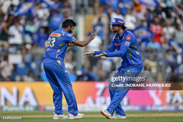 Mumbai Indians' Jasprit Bumrah celebrates with his teammate after taking the wicket of Delhi Capitals' Prithvi Shaw during the Indian Premier League...