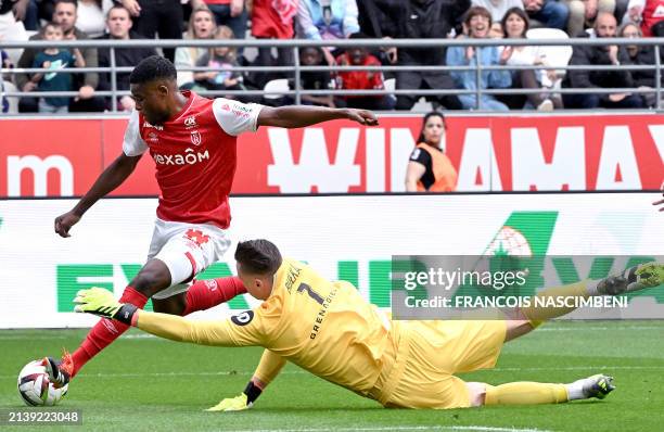 Reims' Zimbabwean midfielder Marshall Nyasha Munetsi fights for the ball with Nice's Polish goalkeeper Marcin Bulka during the French L1 football...