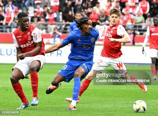 Nice's French midfielder Khephren Thuram fights for the ball with Reims' Zimbabwean midfielder Marshall Nyasha Munetsi and Reims' Belgian defender...