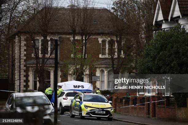 Police officers work behind a cordon set up in a street near to the ground where a man was murdered the night before, as fans start to arrive for the...