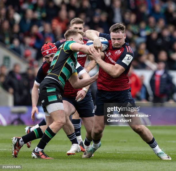 Northampton Saints' Fin Smith competing with Munster's Sean O'Brien during the Investec Champions Cup Round of 16 match between Northampton Saints...