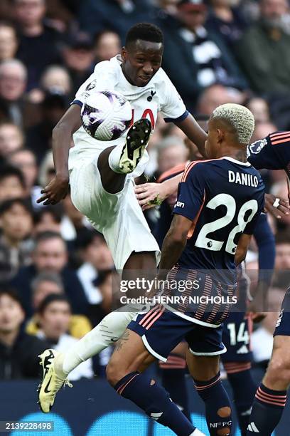 Tottenham Hotspur's Senegalese midfielder Pape Matar Sarr vies with Nottingham Forest's Brazilian midfielder Danilo during the English Premier League...