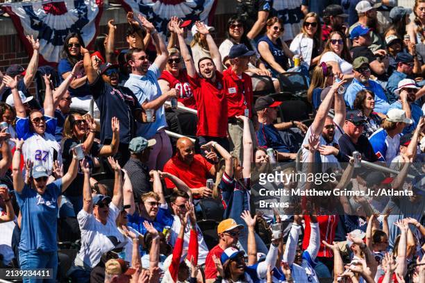 Fans do the wave in the bleachers at Truist park in the fifth inning during the game between the Atlanta Braves and the Arizona Diamondbacks at...