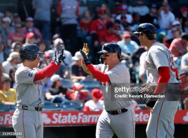 Reese McGuire of the Boston Red Sox is congratulated after hitting a three run home run to score Masataka Yoshida and Triston Casas of the Boston Red...
