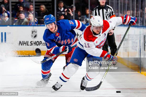 Brendan Gallagher of the Montreal Canadiens skates with the puck against Adam Fox of the New York Rangers at Madison Square Garden on April 7, 2024...