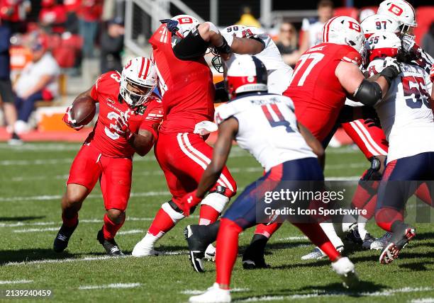 Defenders running back Cam'Ron Harris Sr. Rushes up field while attempting to elude Houston Roughnecks defensive back Jimmy Moreland during the UFL...