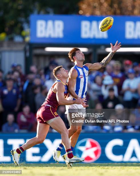 Jy Simpkin of the Kangaroos and Dayne Zorko of the Lions compete for the ball during the 2024 AFL Round 04 match between the Brisbane Lions and the...