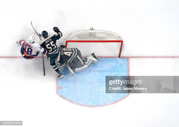 David Jiricek of the Columbus Blue Jackets and Pierre Engvall of the New York Islanders collides into Daniil Tarasov of the Columbus Blue Jackets...