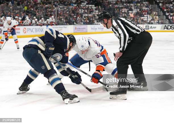 Cole Sillinger of the Columbus Blue Jackets faces off against Casey Cizikas of the New York Islanders during the first period at Nationwide Arena on...