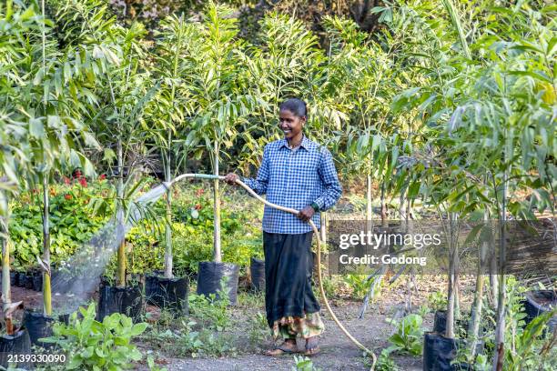 Gardener watering one of the gardens at Goverdan ecovillage, Maharashtra, India.