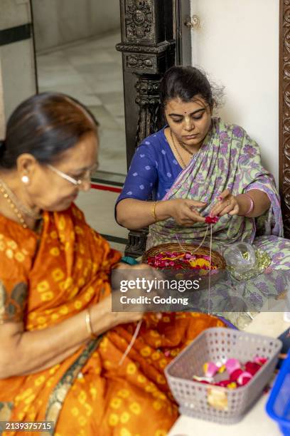 Woman making garlands at ISKCON temple in Juhu, Mumbai, India.