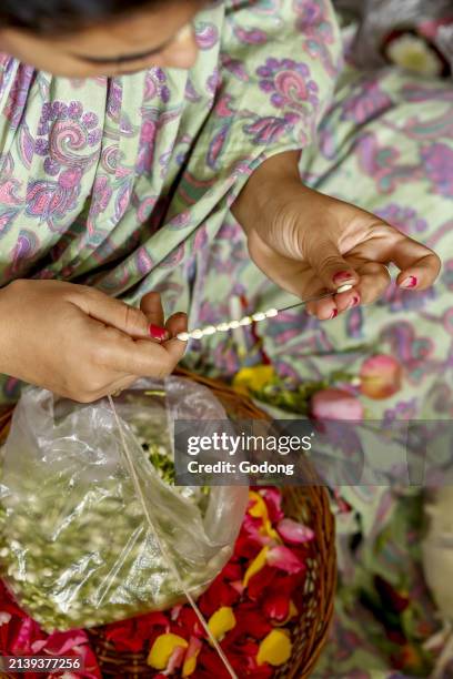 Woman making garlands at ISKCON temple in Juhu, Mumbai, India.