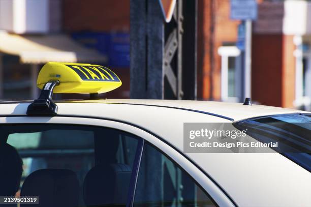 Yellow Taxi Sign on Top of A White Car. Hamburg, Germany.