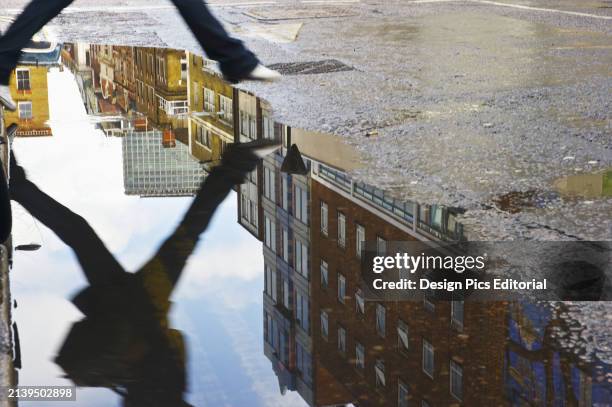 Reflection of A Person Jumping Over A Puddle After The Rain, Soho. London, England.