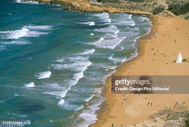 Aerial view of a beach with sunbathers. Gozo Island, Republic of Malta.