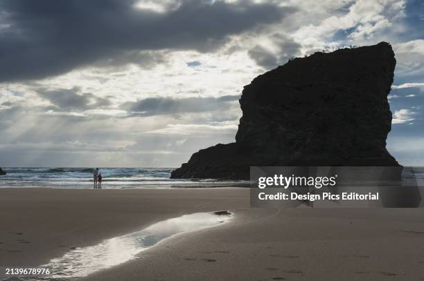 Mother and Daughter on Beach at Bedruthan Steps. Cornwall, England.