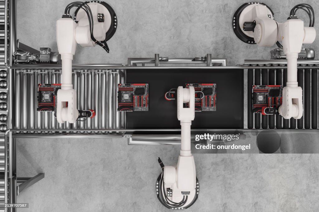 Hochwinkelansicht von Leiterplatten auf der Produktionslinie mit Roboterarmen, die an