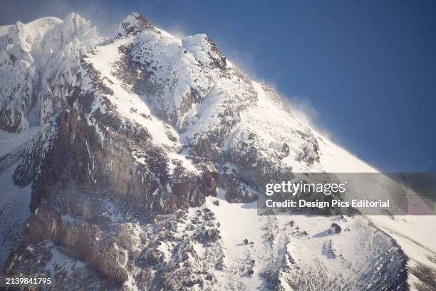 Snow dust and drifting on the steep and rugged mountain slopes, Mount Hood National Forest. Oregon, United States of America.