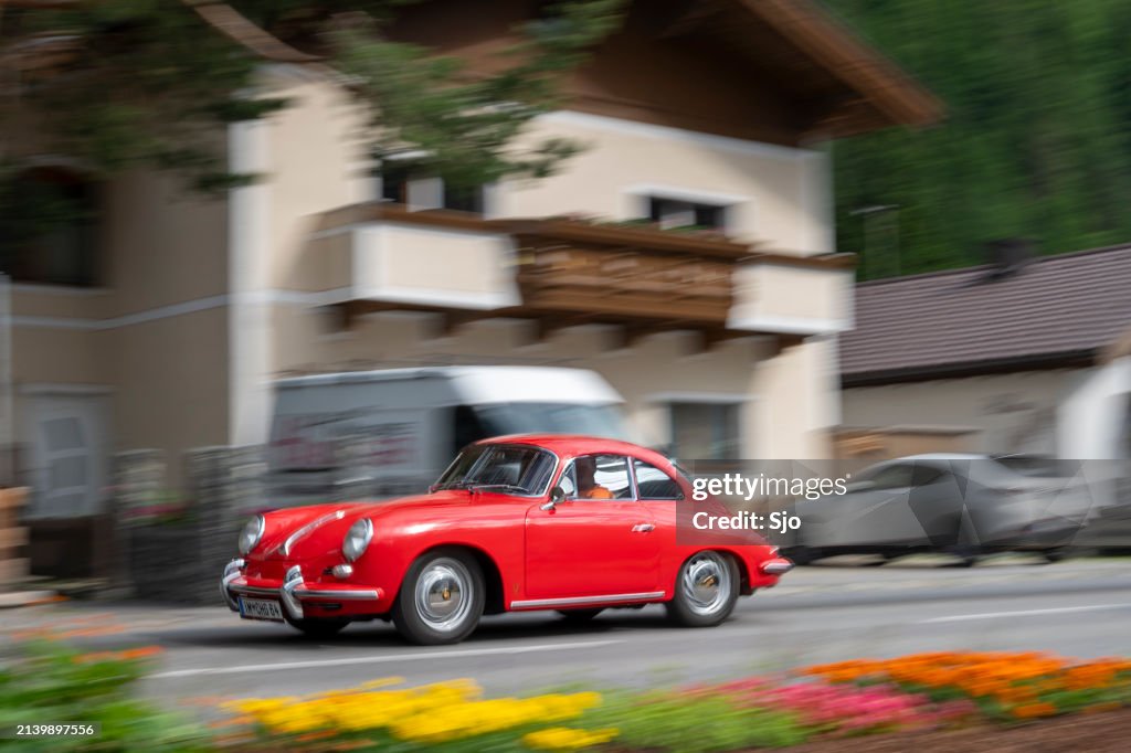 Porsche 356 classic sports car driving in the Alps