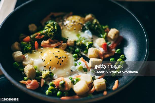 closeup of fried eggs and vegetables in a frying pan. - spinach frittata stock pictures, royalty-free photos & images