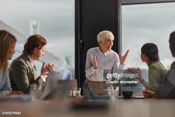 frustrated senior ceo arguing with her colleague on a meeting in the office. - conflict stock pictures, royalty-free photos & images