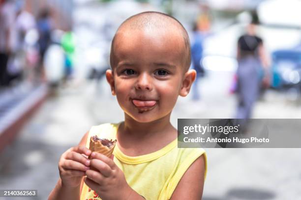 child savoring a chocolate ice cream in kuala lumpur's chinatown - sorvete chocolate chip - fotografias e filmes do acervo