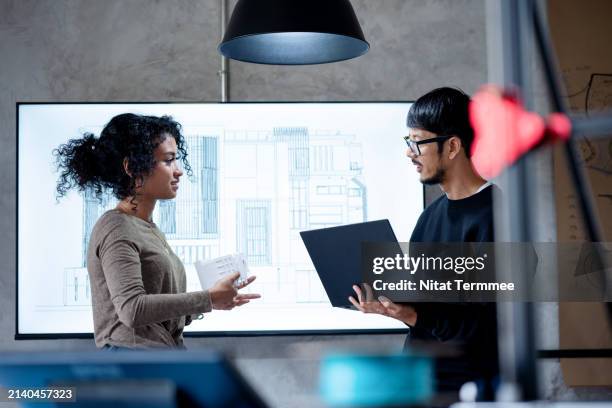 comprehensive project modelling with bim tool to reduce construction project error. a female construction project manager on a project design discusses with her team how to reduce errors during the design phase in an architect's office. - flexible screen stock pictures, royalty-free photos & images