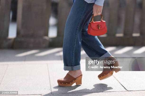 Sonia Lyson seen wearing Levi’s dark blue denim straight leg long pants, Gucci bamboo red / orange round leather mini bag and Scholl platform wood /...